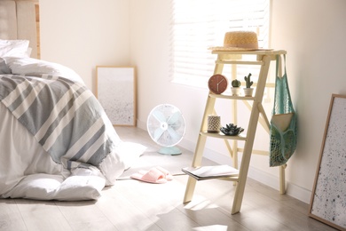 Decorative ladder with different stuff in stylish bedroom. Idea for interior design