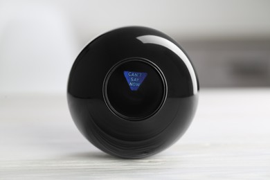 Photo of Magic eight ball with prediction Can't Say Now on light table, closeup
