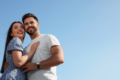 Romantic date. Beautiful couple spending time together against blue sky, low angle view with space for text