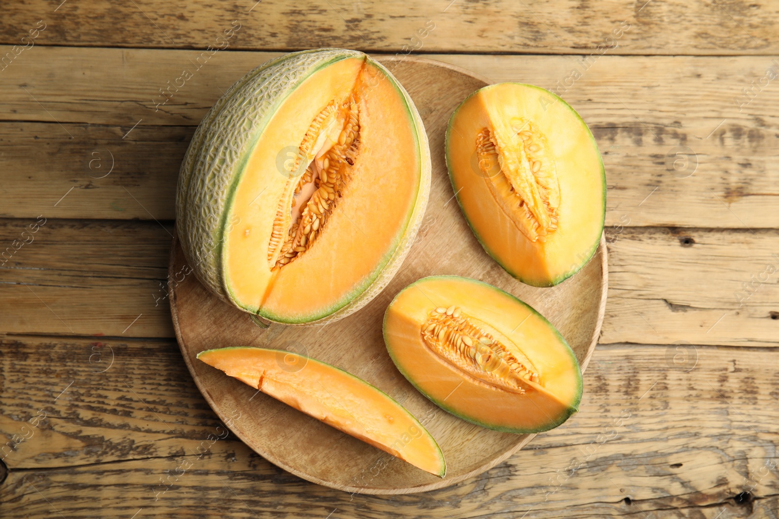 Photo of Tasty fresh cut melons on wooden table, top view