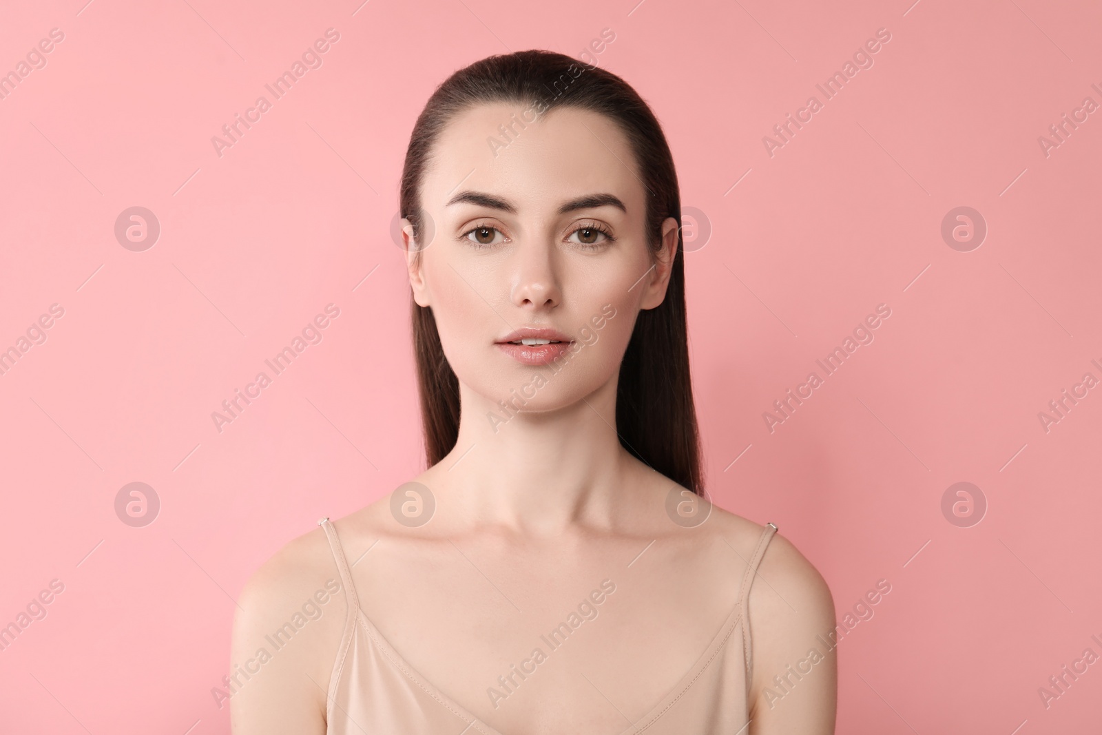 Photo of Portrait of beautiful young woman on pink background