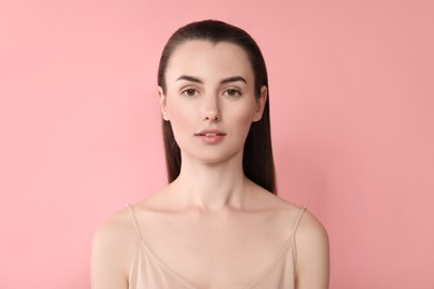 Portrait of beautiful young woman on pink background