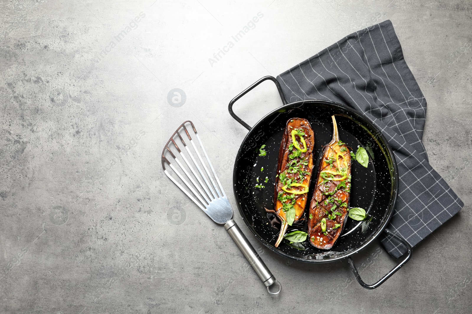 Photo of Frying pan with fried eggplant slices on table, top view. Space for text