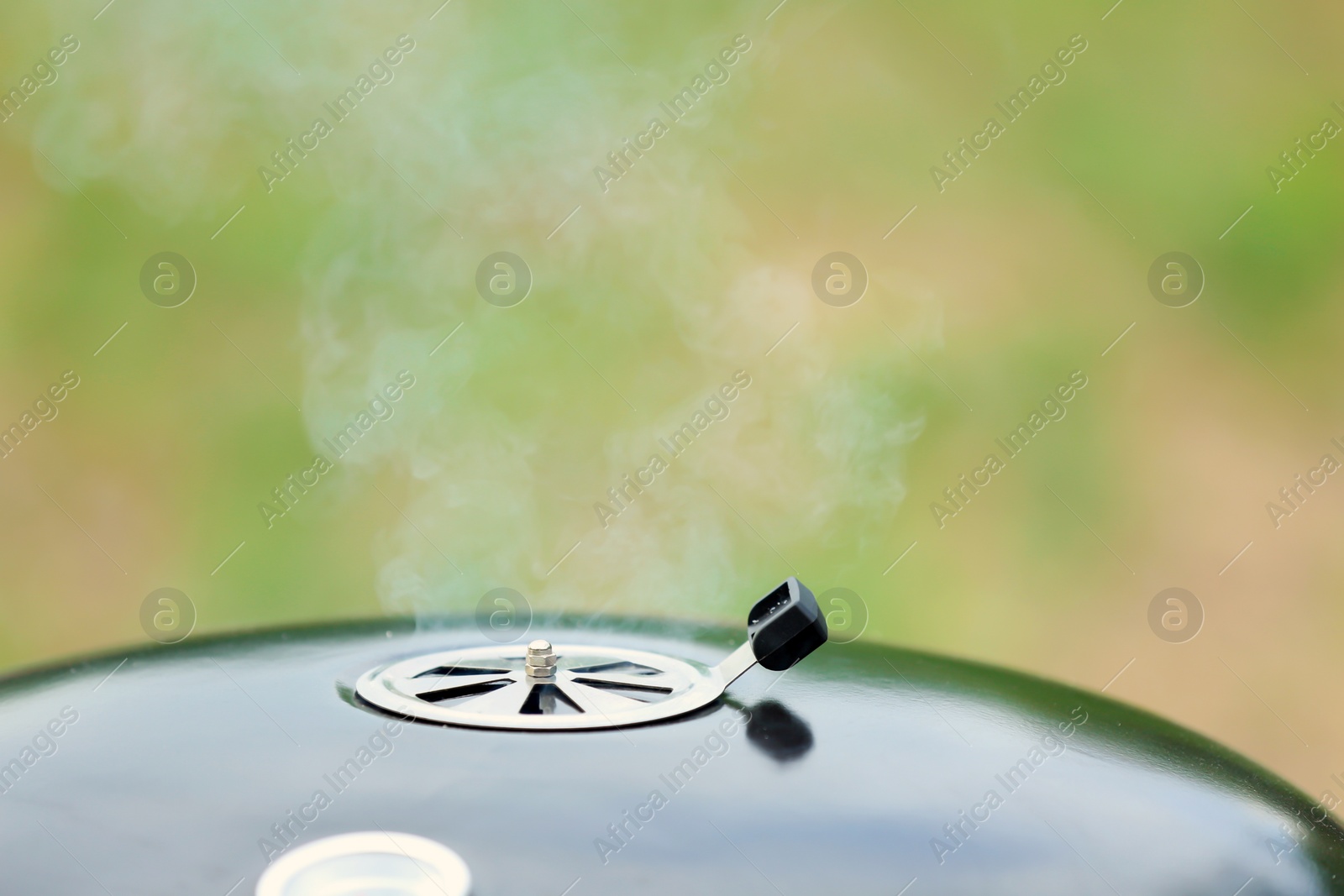 Photo of New modern barbecue grill on blurred background, closeup