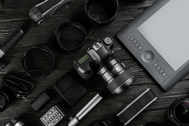 Photo of Flat lay composition with equipment for professional photographer on black wooden table