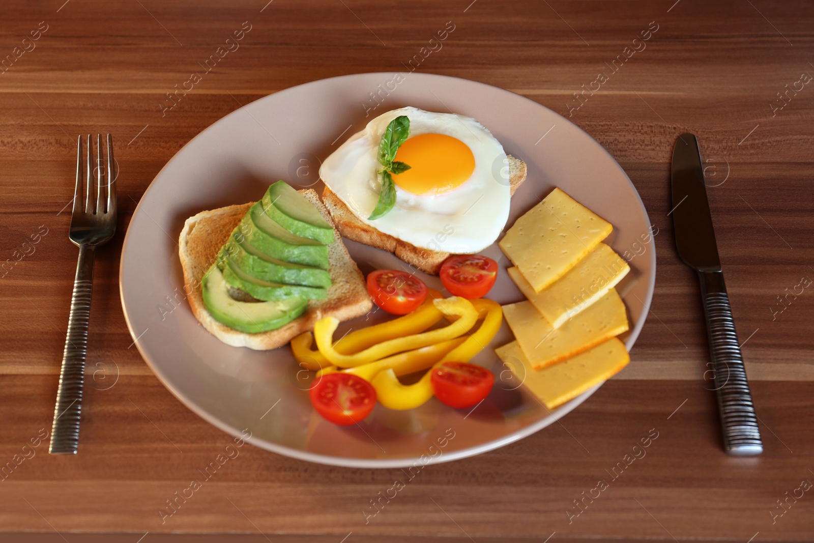 Photo of Tasty toasts with fried egg, avocado, cheese and vegetables served on wooden table