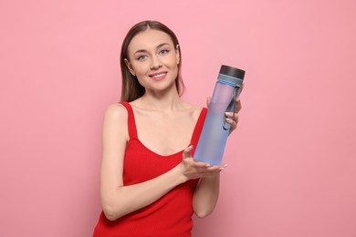 Photo of Beautiful young woman with transparent bottle for water on pink background