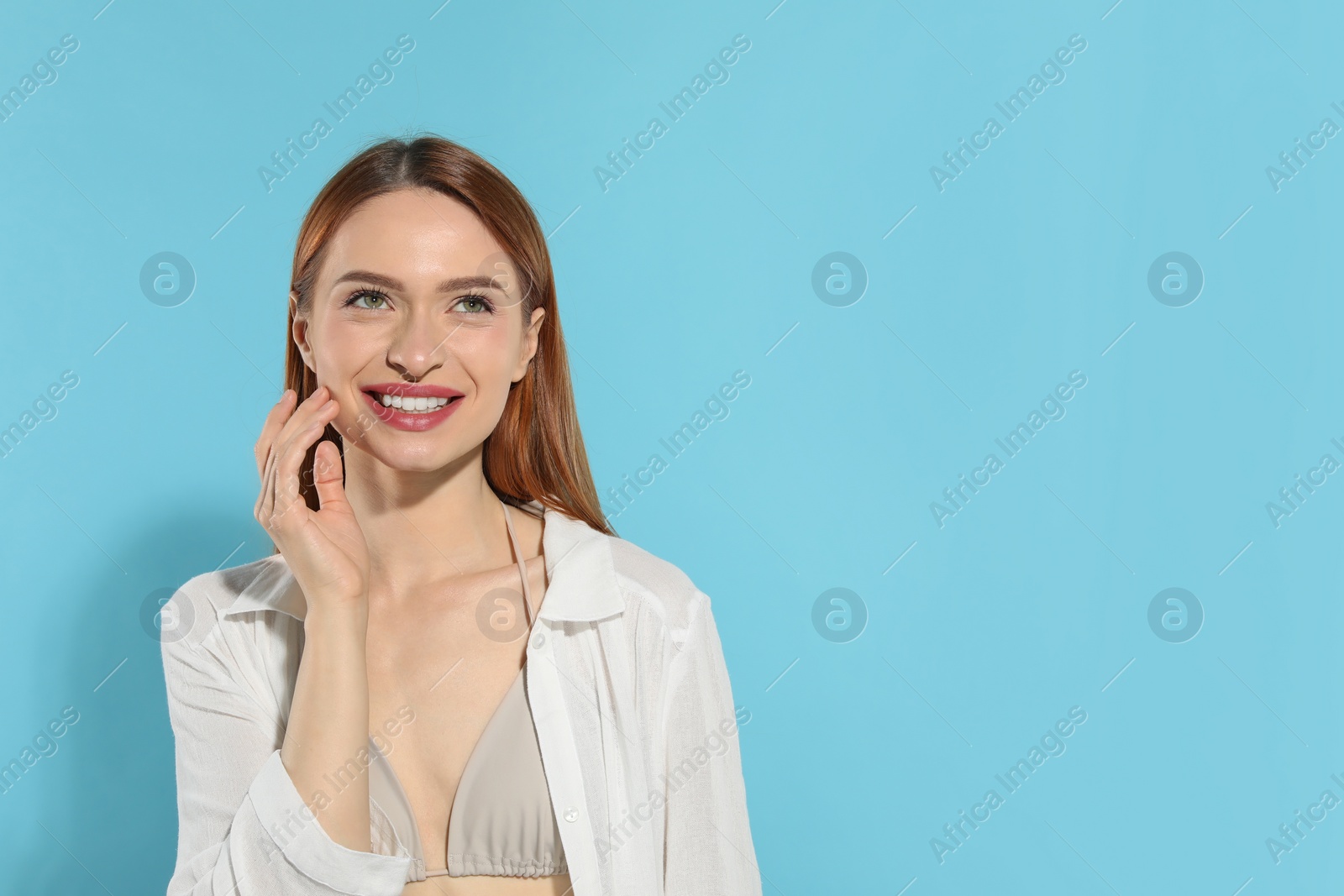 Photo of Beautiful young woman on light blue background, space for text