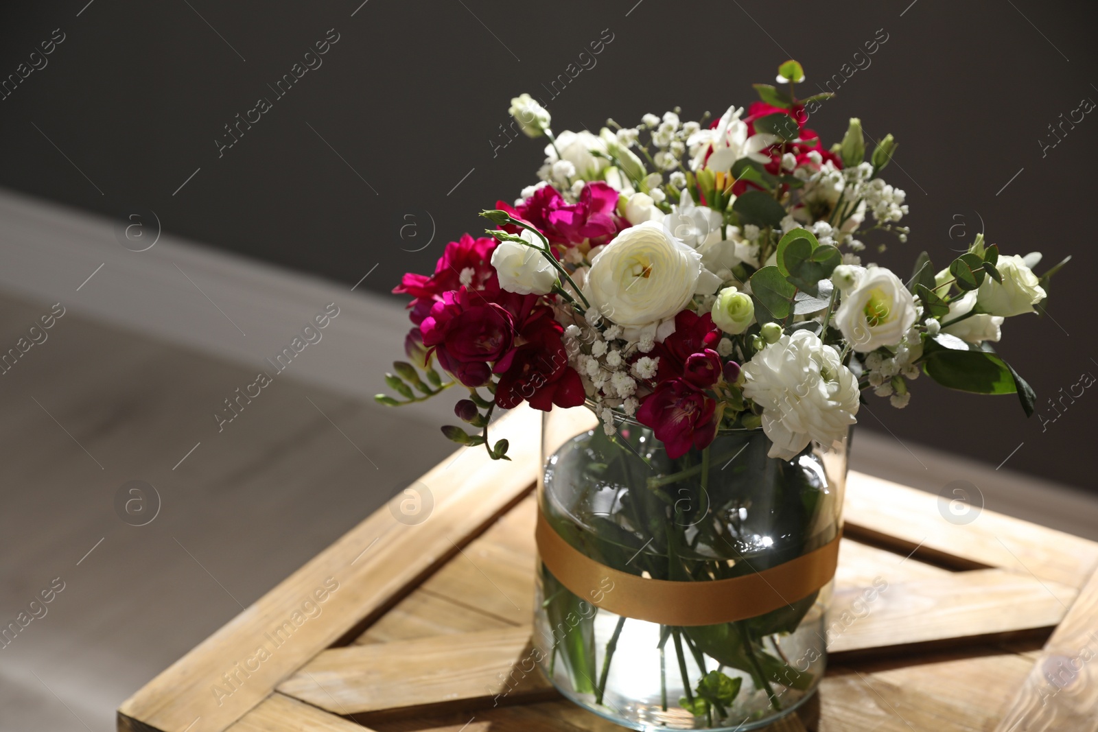 Photo of Beautiful sunlit bouquet with spring freesia flowers indoors. Space for text