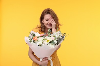 Photo of Happy woman with bouquet of beautiful flowers on yellow background