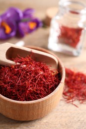 Dried saffron and crocus flowers on wooden table, closeup