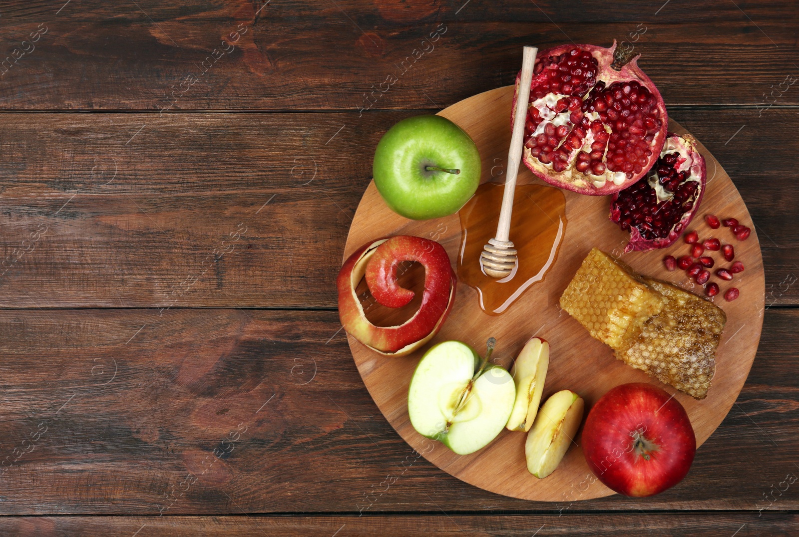 Photo of Honey, apples and pomegranate on wooden table, top view with space for text. Rosh Hashanah holiday