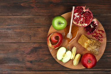 Photo of Honey, apples and pomegranate on wooden table, top view with space for text. Rosh Hashanah holiday