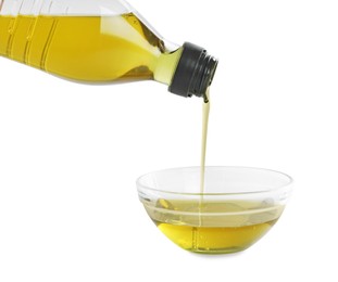 Pouring cooking oil from bottle into bowl on white background, closeup