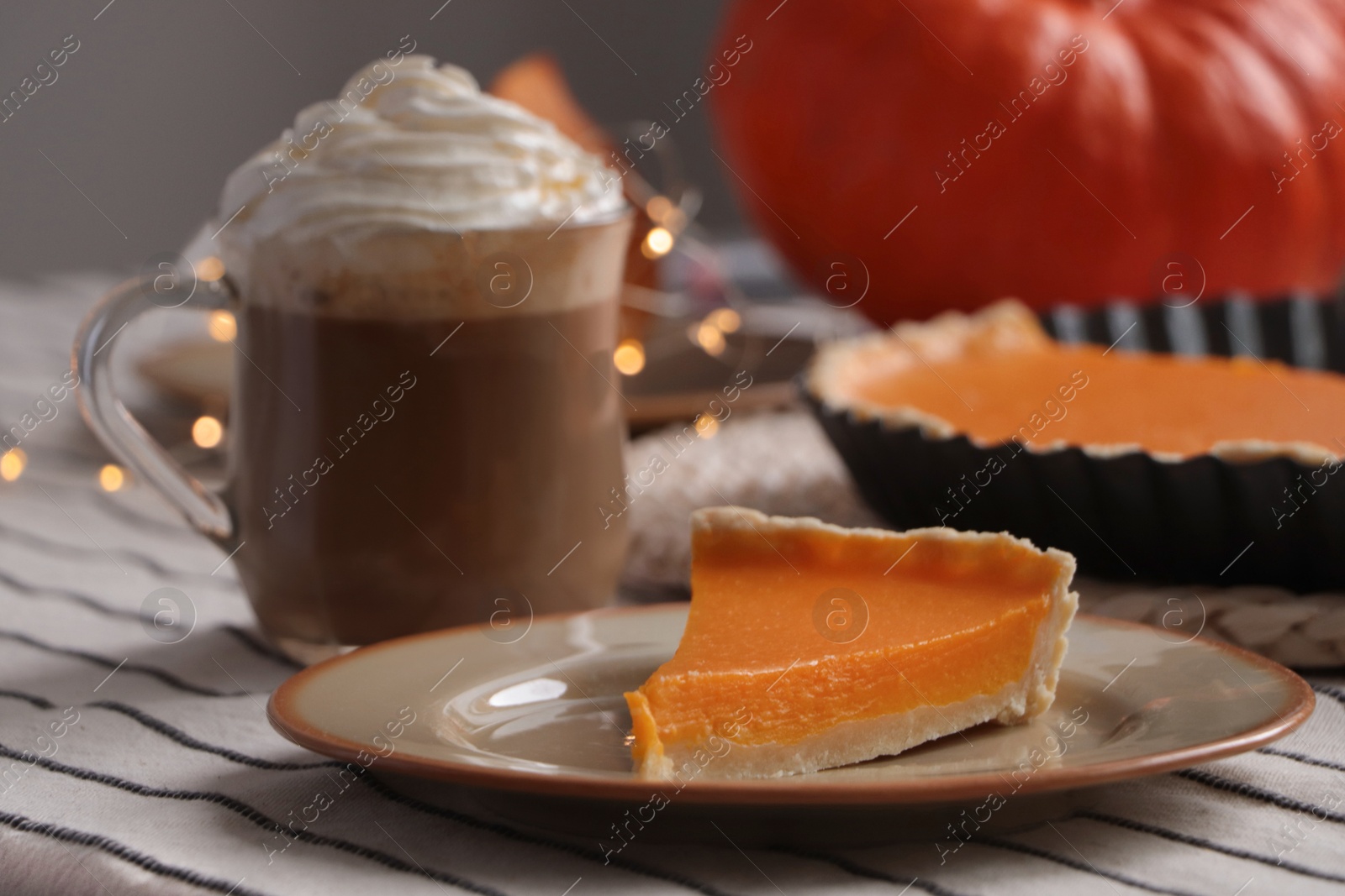 Photo of Fresh homemade pumpkin pie and cup of cocoa with whipped cream on table