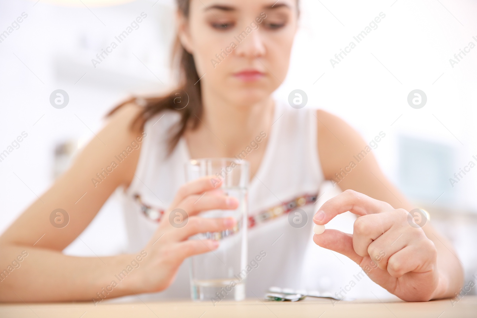 Photo of Young woman holding pill, closeup