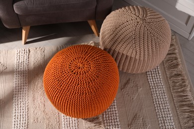 Stylish knitted poufs in room. Home design