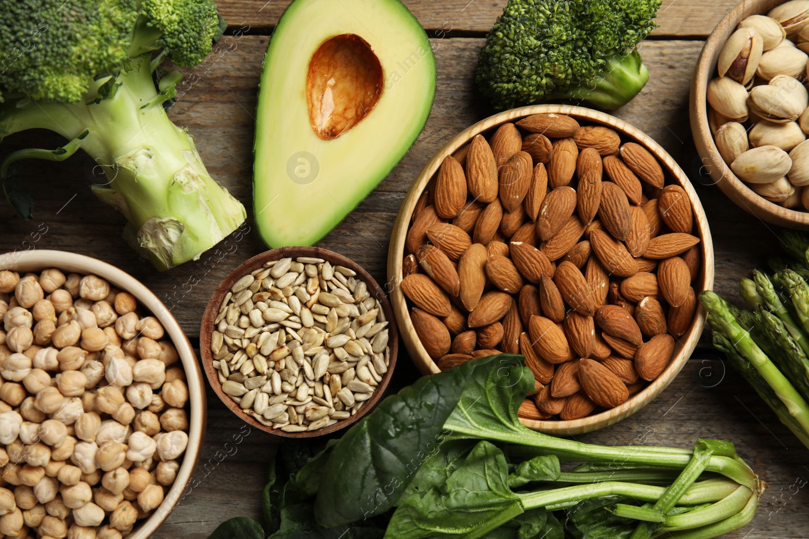 Photo of Different products rich in vitamin E on wooden table, flat lay