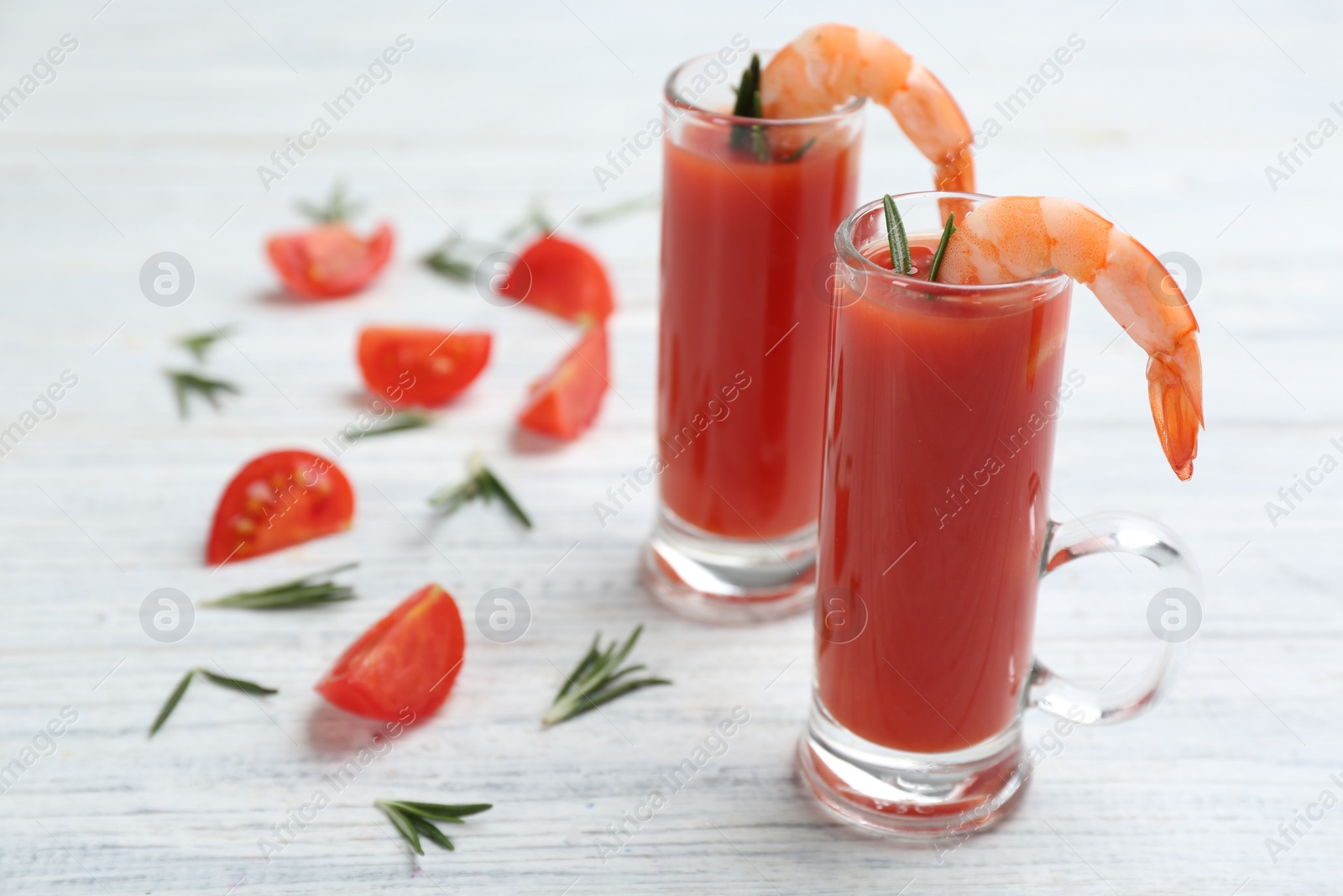 Photo of Shrimp cocktail with tomato sauce on white wooden table