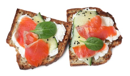 Delicious sandwiches with cream cheese, salmon, cucumber and spinach on white background, top view