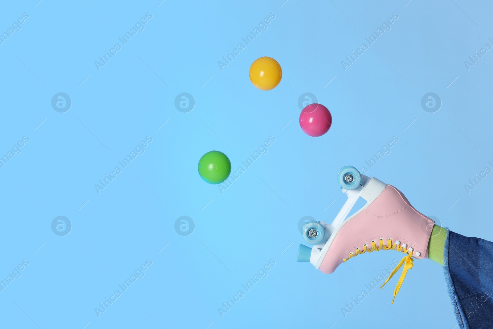 Photo of Woman with vintage roller skate and balls on color background, closeup. Space for text