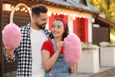 Happy couple with cotton candies spending time together outdoors