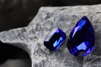 Two beautiful blue gemstones for jewelry on stone surface, closeup. Space for text