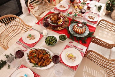 Photo of Festive dinner with delicious food and wine on table indoors, above view. Christmas Eve celebration