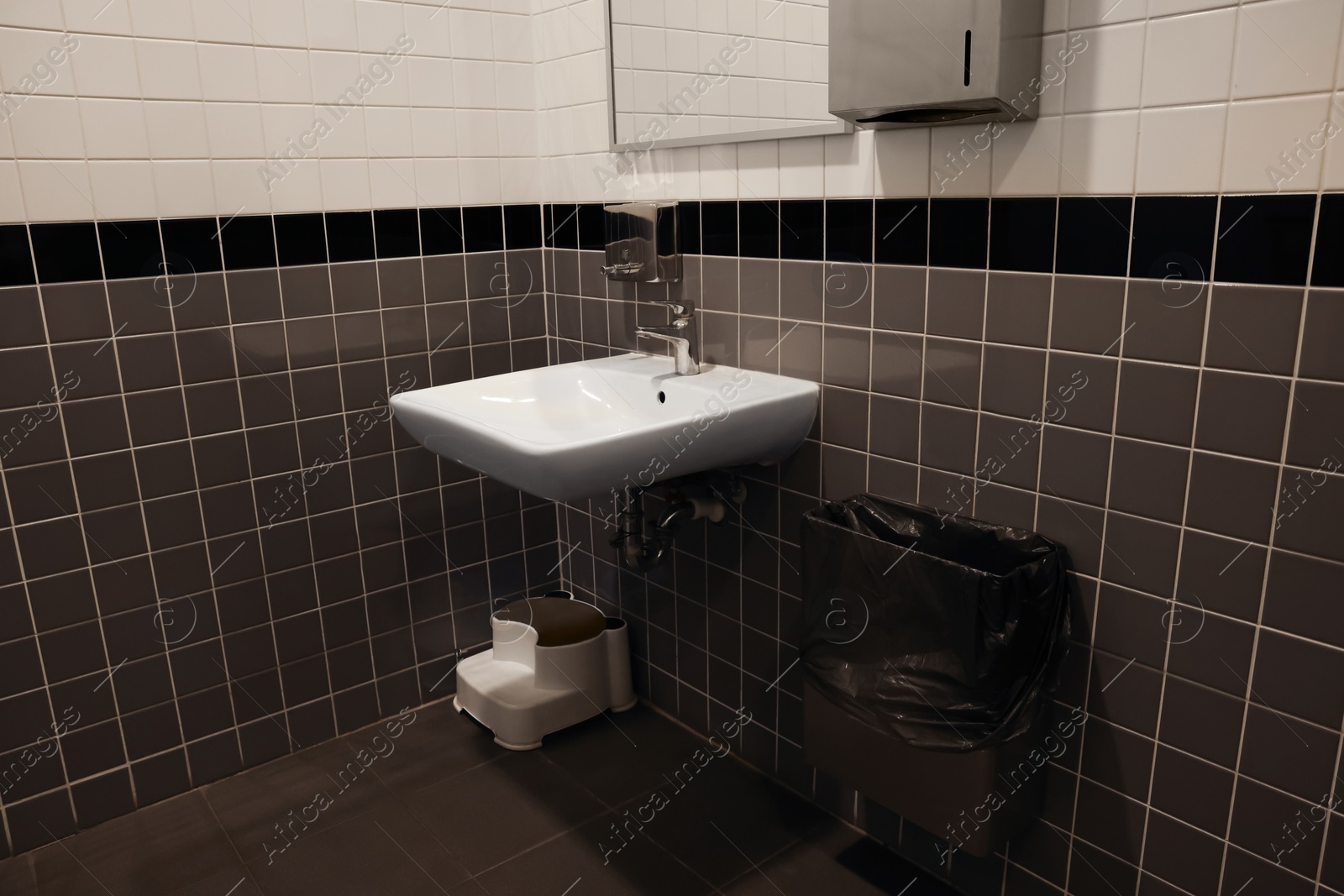 Photo of Public toilet interior with sink and mirror