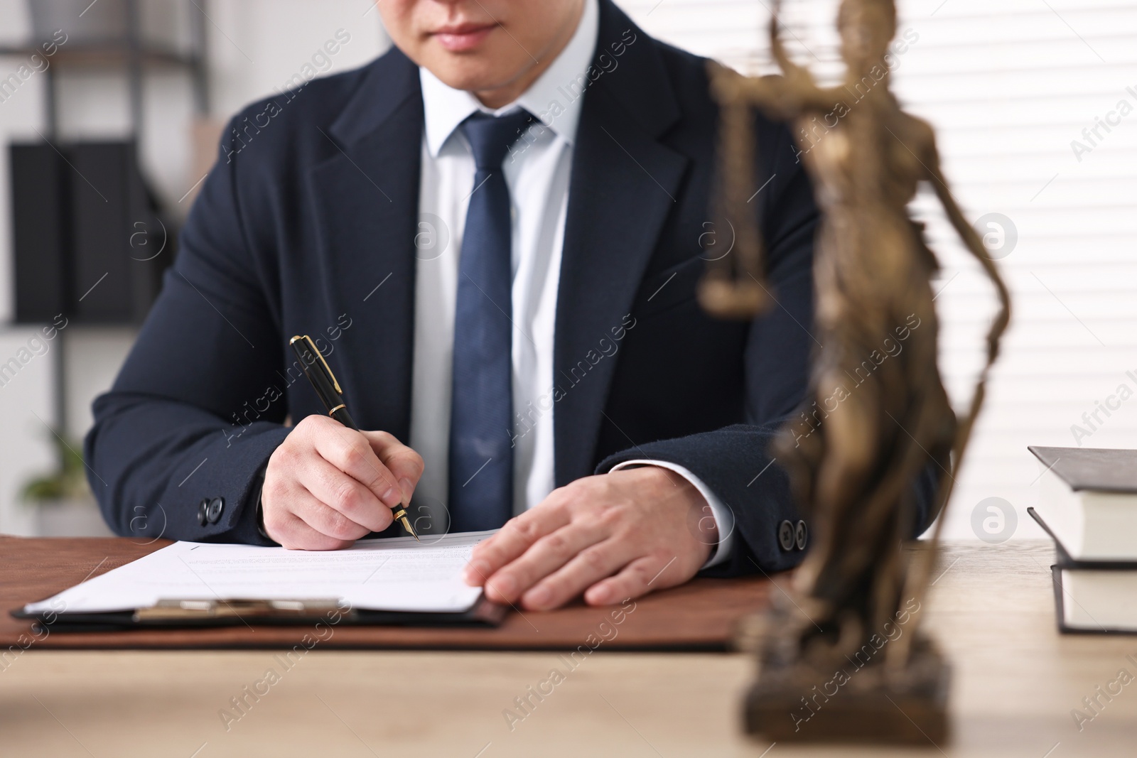 Photo of Notary working at wooden table in office, closeup