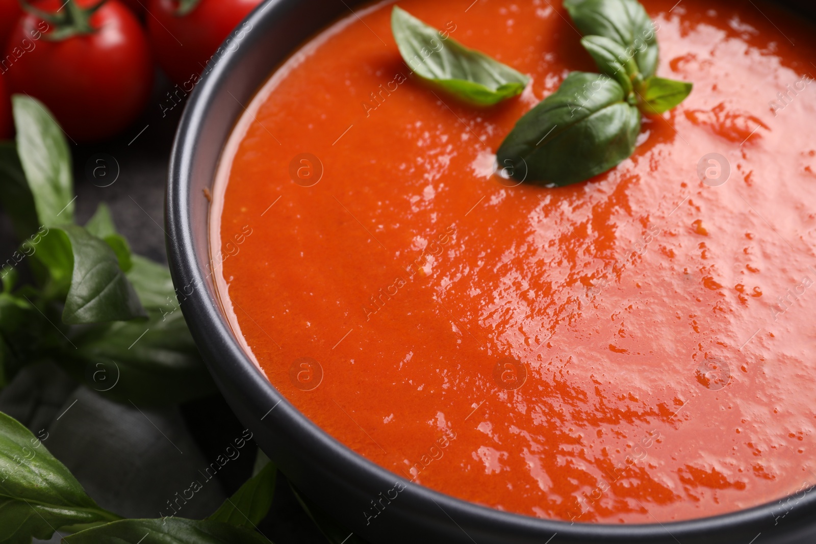 Photo of Delicious tomato cream soup in bowl on table, closeup