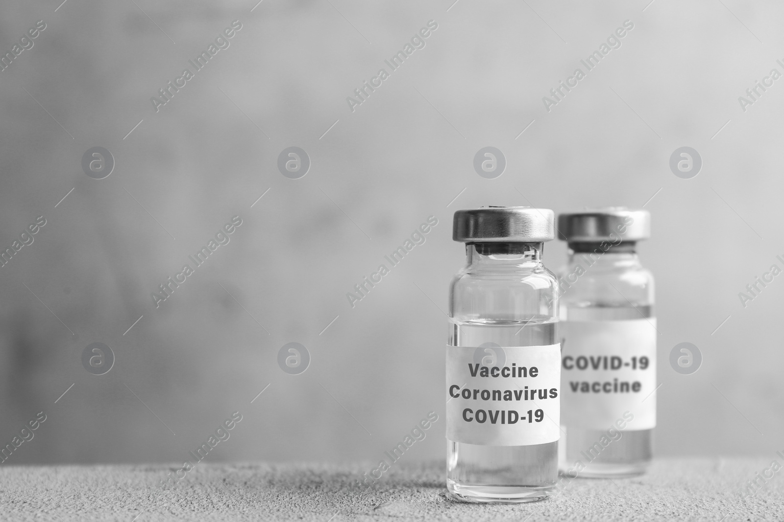 Image of Coronavirus vaccine on grey table, space for text
