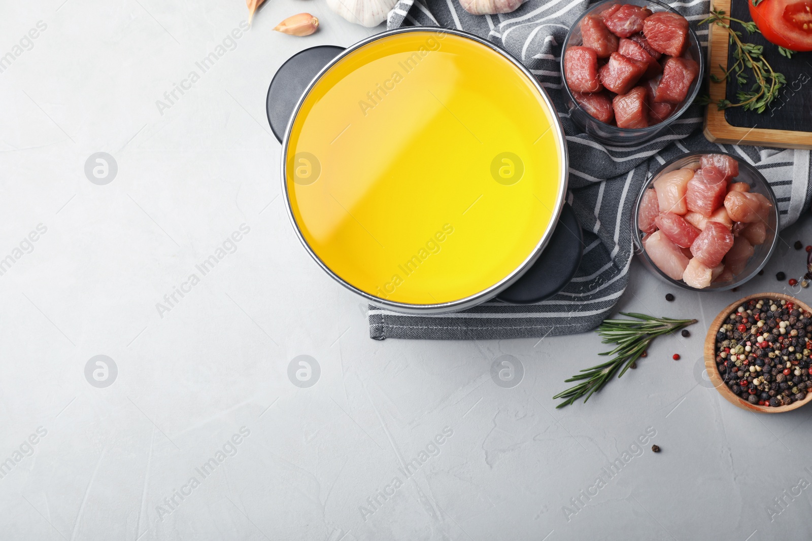 Photo of Flat lay composition with fondue pot, meat and space for text on table