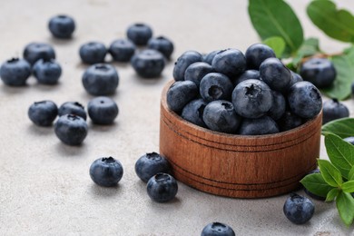 Tasty fresh blueberries on light grey table, closeup