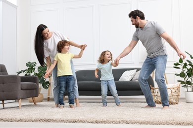 Photo of Happy family dancing in living room, low angle view