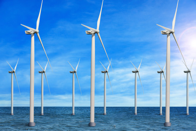 Image of Floating wind turbines installed in sea under blue sky. Alternative energy source 