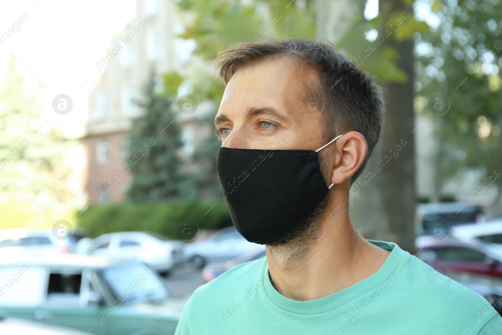 Photo of Man wearing handmade cloth mask outdoors. Personal protective equipment during COVID-19 pandemic