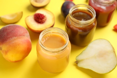 Healthy baby food and ingredients on yellow background