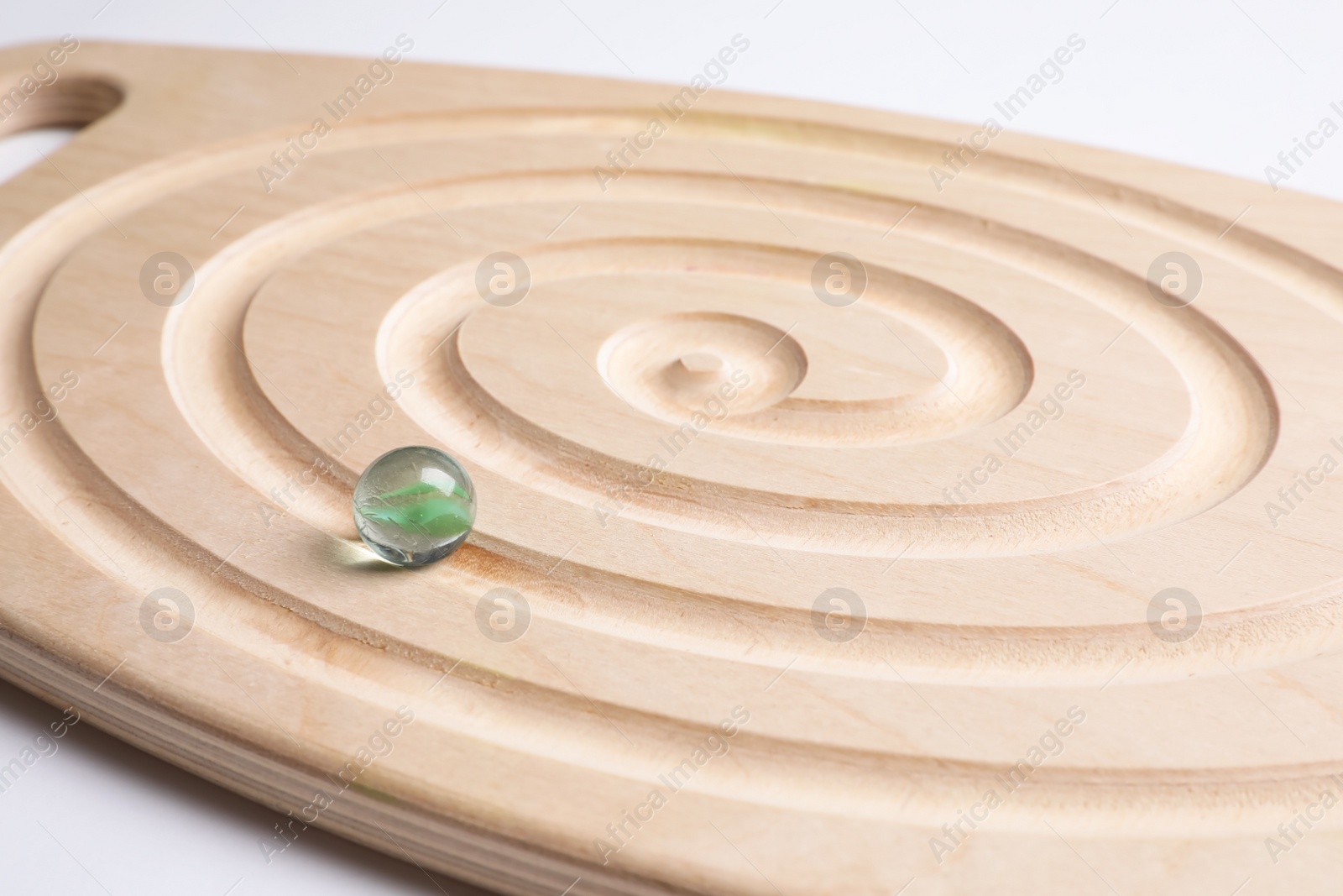 Photo of Wooden labyrinth balance board on white background, closeup. Montessori toy