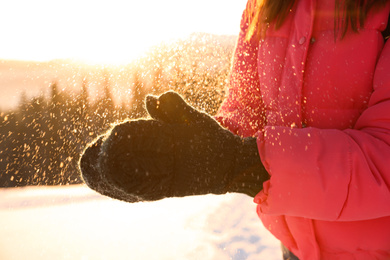 Photo of Young woman having fun outdoors on snowy winter day, closeup