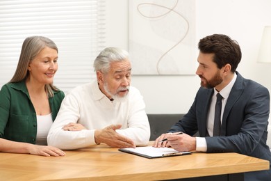 Notary consulting senior couple about Last Will and Testament in office