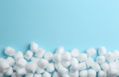 Photo of Many cotton balls and space for text on blue background, top view