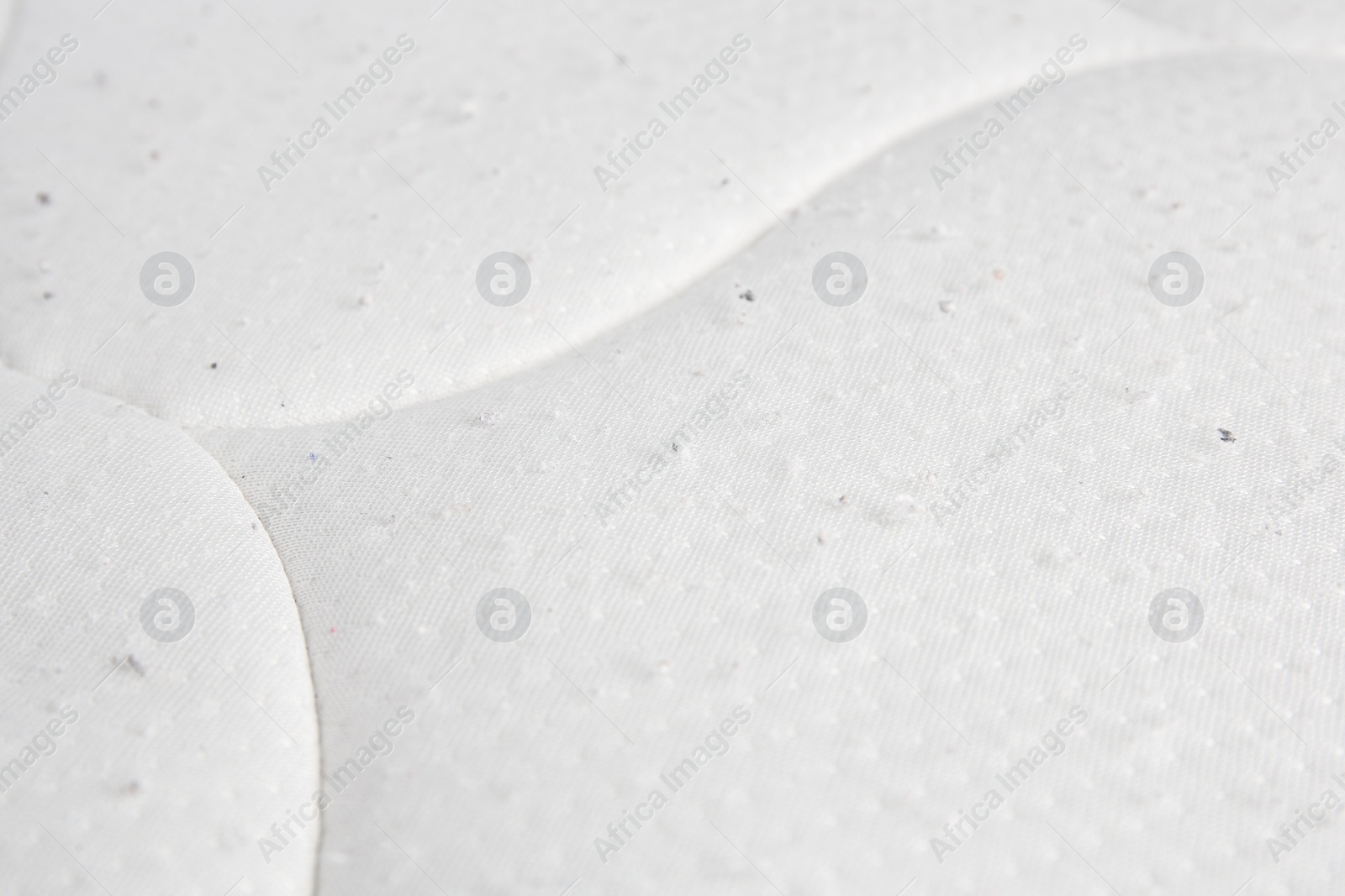 Photo of Mattress with lint as background, closeup. Before use of fabric shaver