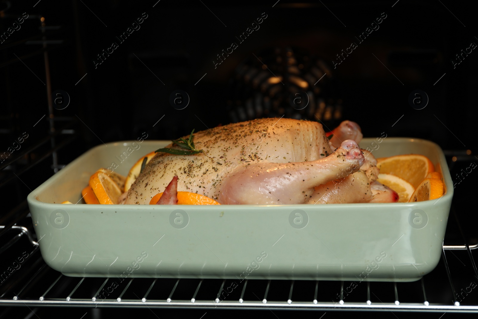 Photo of Chicken with orange slices baking in oven