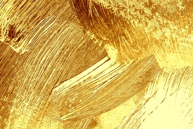 Strokes of golden paint as background, closeup