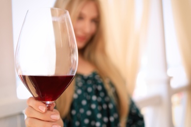 Photo of Young woman holding glass of wine in outdoor restaurant, closeup with space for text