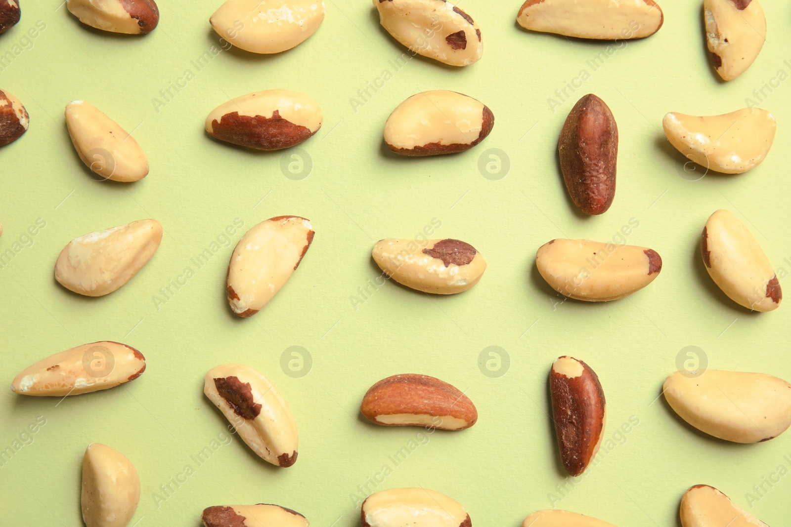 Photo of Flat lay composition with Brazil nuts on color background