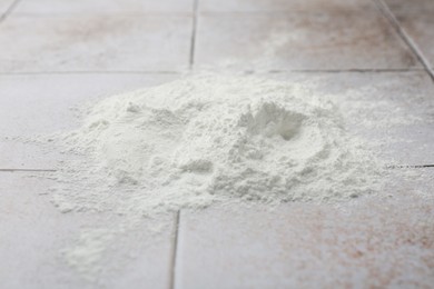 Photo of Pile of baking powder on light tiled table, closeup