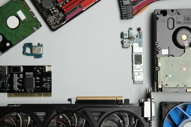 Frame of graphics card and other computer hardware on light background, flat lay. Space for text