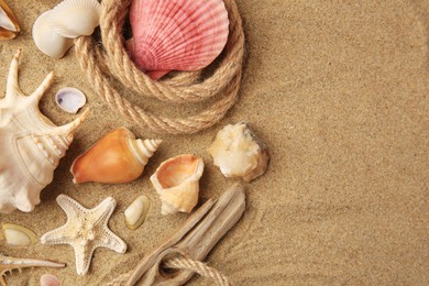 Beautiful sea star, shells and rope on sand, flat lay. Space for text